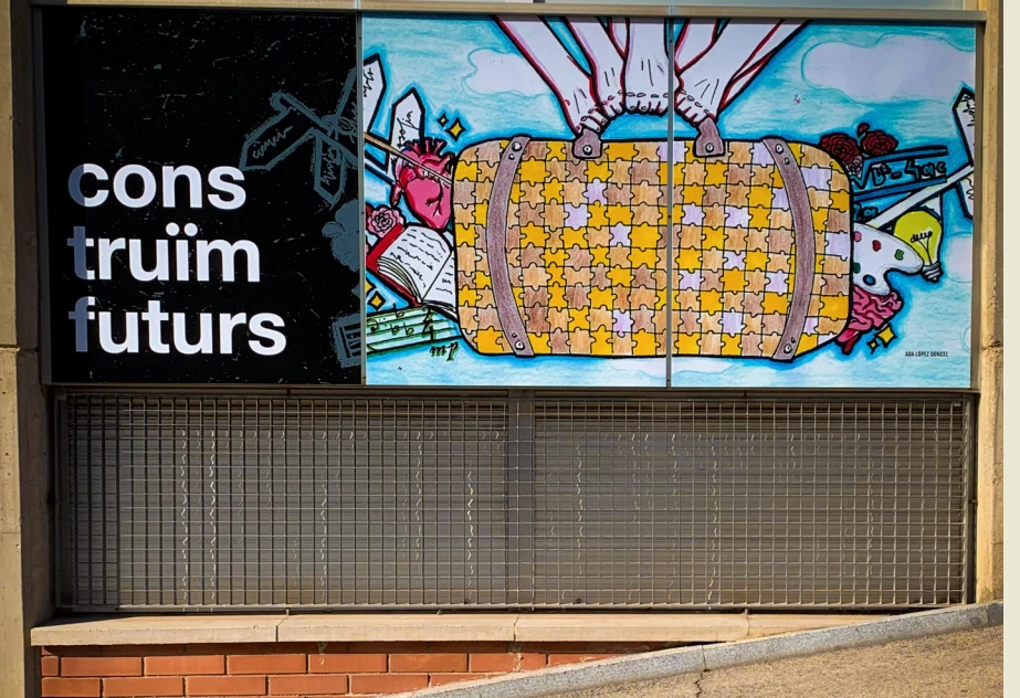 Fotografia del mural exterior del centre amb la frase «construïm futurs» i una il·lustració de colors.